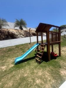 a playground with a blue slide and a ladder at Casa 2 quarto em condomínio in Camaçari
