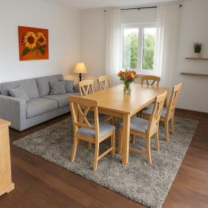 a living room with a wooden table and chairs at Westerwald Apartments - Das große Ferienhaus, zentral und ruhig, einfach gut! in Heiligenroth