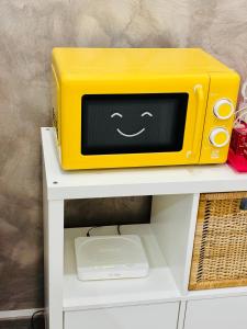 a yellow microwave sitting on top of a white shelf at Sea Beach Pozzallo in Pozzallo
