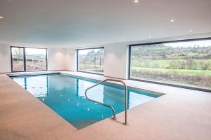 ein Swimmingpool in einem Haus mit Fenstern in der Unterkunft Le Milan in Nassogne