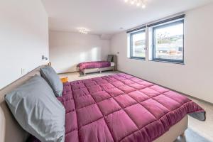 ein Schlafzimmer mit einem großen Bett und einer rosa Decke in der Unterkunft Le Milan in Nassogne + 18 Fotos