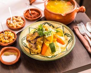 a table topped with a plate of food with vegetables at Le Bretonneau Ledru Rollin in Tours