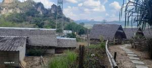 a group of buildings with mountains in the background at Khao Sok Moon Light Hill Camp in Khao Sok National Park