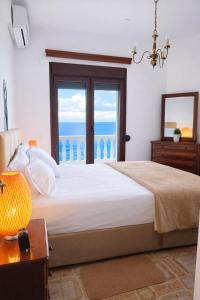 a bedroom with a bed with a view of the ocean at Blue Dandelion in Paliouri