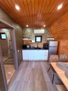 a kitchen with white cabinets and a wooden ceiling at Cabana AFrame Olanesti in Băile Olăneşti