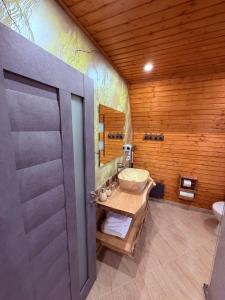 a bathroom with a sink and a wooden wall at Cabana AFrame Olanesti in Băile Olăneşti +144 photos