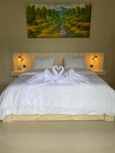 a bedroom with a white bed with a white blanket at the gosana in Amed