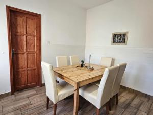 a dining room table with white chairs and a wooden table at Bányász Vendégház in Csokvaomány +39 photos