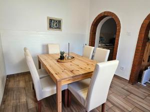 a dining room table with white chairs around it at Bányász Vendégház in Csokvaomány