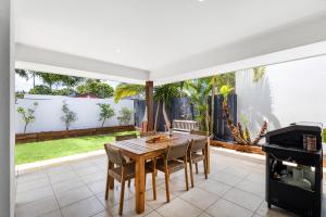 a dining room with a table and chairs at Mooloolaba Parkway Palms Spacious 3BR with Patio & BBQ Pet-Friendly near the Beach in Mooloolaba