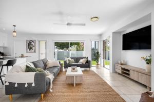 a living room with two couches and a tv at Mooloolaba Parkway Palms Spacious 3BR with Patio & BBQ Pet-Friendly near the Beach in Mooloolaba