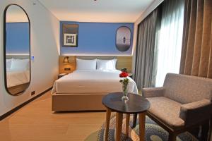 a hotel room with a bed and a chair at Sands Point Hotel in Pondicherry +34 photos