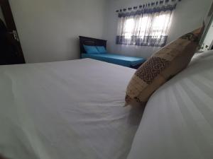 a bedroom with a large white bed and a window at AIRA in Galle