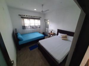 a bedroom with a bed and a blue couch at AIRA in Galle