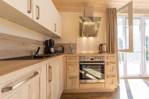 a kitchen with wooden cabinets and a stove and a sink at Patryzia in Lenz