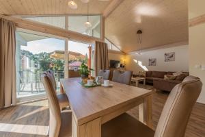 a dining room and living room with a wooden table and chairs at Patryzia in Lenz