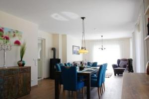 a dining room with a table and blue chairs at Peter in Lenz