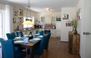 a dining room with a table and blue chairs at Peter in Lenz