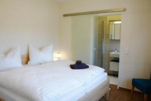 a bedroom with a white bed with a hat on it at Peter in Lenz +7 photos