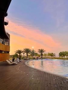 a pool at a resort with palm trees and a sunset at Casita Luna in San Juan