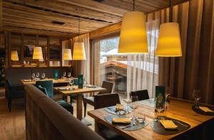 a restaurant with wooden tables and chairs and yellow lights at Mont Chalet Nevada - Hotel & Spa in Livigno