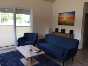 a living room with a blue couch and a coffee table at Kerstin in Lenz