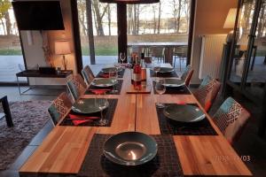 a long wooden table with chairs and glasses on it at Seehaus in Lenz