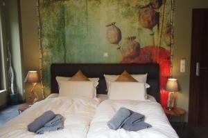two beds in a bedroom with a painting on the wall at Seehaus in Lenz +11 photos