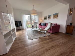 a living room with a pink couch and a table at Seemöwe in Lenz +10 photos