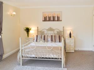 a bedroom with a white bed and two dressers at Rosecraddoc Manor - Riverview in Saint Cleer