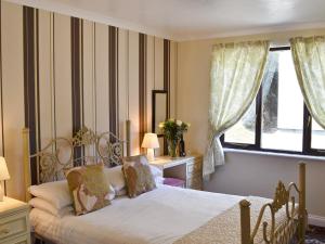 a bedroom with a bed and a window at Rosecraddoc Manor - Riverview in Saint Cleer