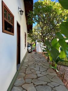 a stone walkway next to a building with a tree at Atelier-Aconchego e Fitness in Pirenópolis