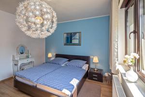 a blue bedroom with a bed and a chandelier at Lago EG in Lenz