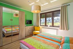 a bedroom with green walls and a bed and a chair at Lago EG in Lenz