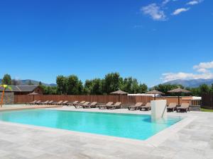 a swimming pool with chaise lounge chairs at Bungalows Pirineus in Guils de Cerdaña
