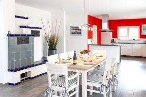 a kitchen with a white table and chairs and red at Michael in Lenz