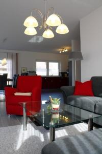 a living room with a red couch and a glass table at Valentina in Lenz