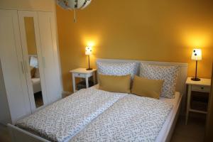 a bedroom with a bed with two lamps on two tables at Trine in Lenz