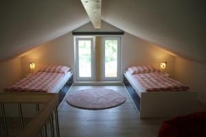 a attic room with two beds and a window at Trine in Lenz +3 photos