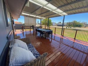 a porch with a table and chairs on a deck at Cervantes 4 G Ranch in Cervantes