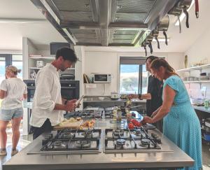 a group of people in a kitchen preparing food at Penny's Drop Inn in Cromwell