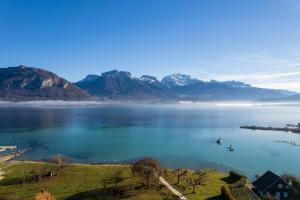 a view of a large body of water with mountains at Le Chalet de la Plage in Sévrier