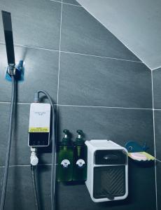 a tiled bathroom with a shower with a soap dispenser and bottles at Start House 5 mins walk Airport in Ho Chi Minh City