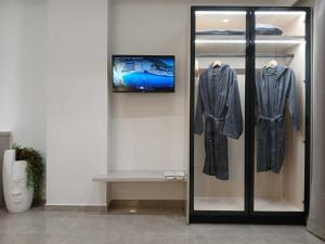 a display case in a room with a tv and clothes at Olympian Gods apartments in Alikanas