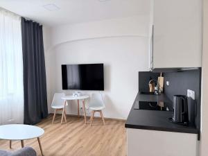a kitchen with a table and a tv on the wall at Parkány Litoměřice in Litoměřice