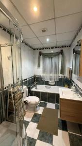 a bathroom with a toilet and a tub and a sink at Flat 3 in Mġarr