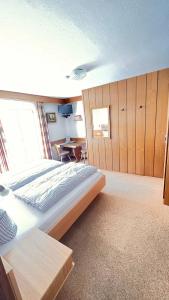 a bedroom with a large bed and a table at Das Alpenglühn Hotel & Restaurant in Krün