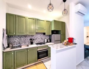 a kitchen with green cabinets and a counter top at Casa André Imola in Imola
