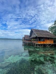 a row of houses on a pier in the water at Raja Ampat Holidays in Besir