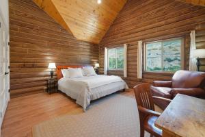 a bedroom with wooden walls and a bed and a chair at Cute Cabin with Mountain Views and King Bed in Provo